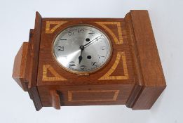 A mahogany inlaid cased eight day movement inlaid mantle clock striking on a coiled gong