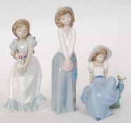 A collection of 3 Nao figurines to include girl with vase and flowers,