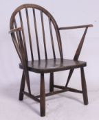 A vintage Low Ercol style childs armchair having saddle seat with arched back and shaped elbow