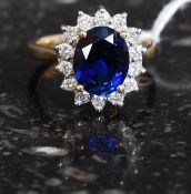 A 9ct gold diamond and sapphire? ladies dress ring. The deep blue stone with diamonds surrouding.