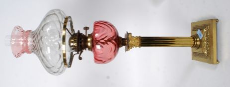 A  20th century  neo classical brass and cranberry glass reservoir oil lamp.