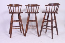 A set of three retro bar / breakfast stools each raised on four turned legs united by stretchers