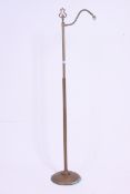 An early 20th century brass standard lamp with terraced base having upright stem and arm above.