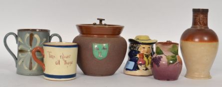 A collection of Cornish studio pottery to include a Torquay ware cup, painted vase and other pieces.