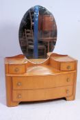 A 1930's Art Deco maple veneer bow front dressing table chest of drawers having oval mirror atop.