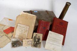A vintage deed box containing military items such as photo's books,