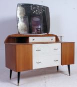 A 1950's two tone teak dresser raised on dansette legs with mirror over wide body with a series of