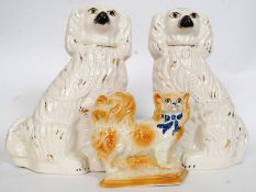 A pair of Victorian Staffordshire fireside spaniels, along with another single Spaniel.