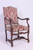 A 19th century walnut upholstered Osso Bucco French provincial fauteuil armchair having shaped legs