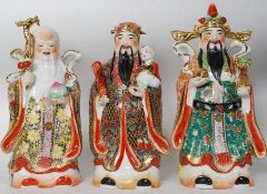 A collection of 3 large Chinese ceramic figurines of immortals having gilded and handpainted finish.