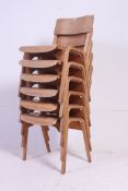 A stack of 6 retro 1950's ply panel wood Industrial school chairs raised on bentwood legs with