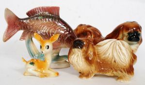 A Jena ceramic Perch ? raised on naturalistic plinth along with two ceramic Shitzu dogs