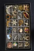 A collection of costume jewellery brooches to include filigree, paste stones, ceramic,