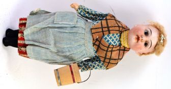 GERMAN DOLL; An antique German made miniature bisque headed doll, with glass eyes.