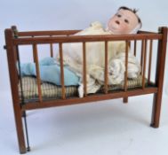 JUTTA DOLL & CRIB; An antique Jutta Baby ceramic headed doll marked 1922 to rear of head,