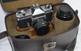 A cased vintage 35mm Chinon camera with several lenses, flash head and other accessories.