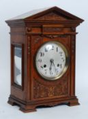 An oak cased eight day mantle clock, enamel dial with Arabic numerals,