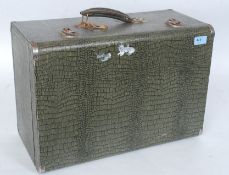 A vintage early 20th century Singer Sewing machine being set within a faux crocodile skin suitcase