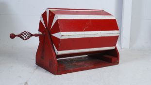 A vintage 1950's painted tombola having hexagonal barrel with twist handle over base being painted