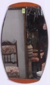 A vintage 1970's teak wood overmantel mirror of oval form together with a footstool on tapered