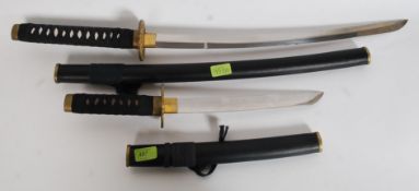 2 replica Japanese Samurai short swords being complete with scabbards and fabric handles.