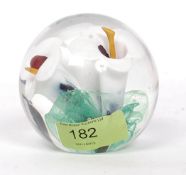 A Langham glass paperweight with white lillies and green leaf control bubble base.