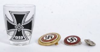 A collection of 20th century nazi memorabilia to include an enamel NSDAP badge being stamped to