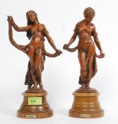 A pair of Art Nouveau Gaiste & Modiste figures. Standing on turned wooden bases.