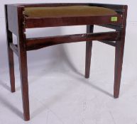 A 1950's metamorphic mahogany piano stool.