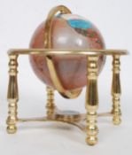A semi precious stone inlaid celestial day and night globe on brass stand with inset compass.