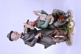 A vintage Capo De Monte figure of two tramps - with signature to base