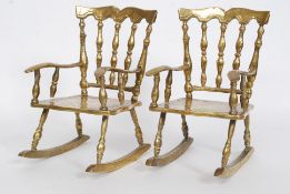 A pair of matching heavy cast brass dolls / teddy bear display rocking chairs.