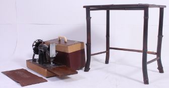 A vintage 1950's Singer sewing machine in two tone original case together with a bamboo side table.