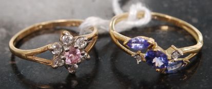 2 ladies 9ct gold rings,one being a flower head ring, the other with amethyst type stones.