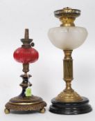A 19th century ceramic and cranberry glass oil lamp together with a Victorian brass's and frosted