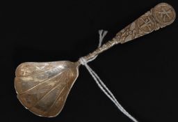 A Chinese silver caddy spoon having decorative shaped bowl with character marks to the handle.