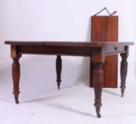 A Victorian large walnut extending wind out dining table raised on reeded turned legs with castors.
