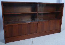 A vintage 1970's low teak library bookcase cabinet having open shelves with sliding door cupboard