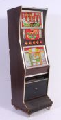A vintage 1960's fruit machine having decorative facia within wooden upright body on castors.