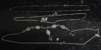 A collection of silver necklaces to include one with bear pendant,