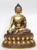 An early 20th century large parcel gilt bronze buddha raised on a lotus base.
