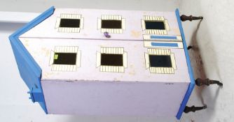 A very tall front opening scratch built dolls house raised on turned legs with ceramic castors,