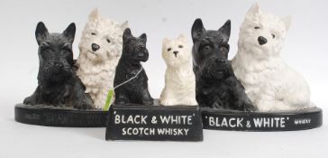 A collection of Black & White Scotch Whisky dog figurines to include 2 ceramic, 1 being resin.