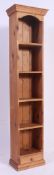 A tall slim solid pine bookcase having adjustable shelving with a singular drawer to base.