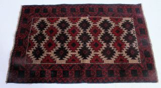 A handwoven Kazak prayer Rug having central diamond lozenges / motifs with red and blue background.