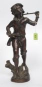 An early 20th cenutry bronze figurine of a young fruit picker - boy raised on a naturalistic plinth