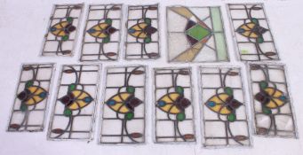 A  collection of 1930's stained glass panels having decorative coloured glass centres with lead