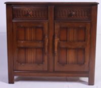 A dark Elm Ercol sideboard , having panel doors below two drawers.
