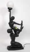 A contemporary Art Deco style figural lamp in the form of a man and lady held aloft.