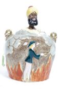 A vintage novelty mid 20th century ceramic biscuit barrel being adorned with a panto Aladdin and